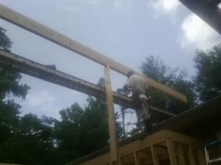 Carpenter setting a ridge beam over a new addition frame — Ice Dam Removal by Roofing Brothers in Lisbon