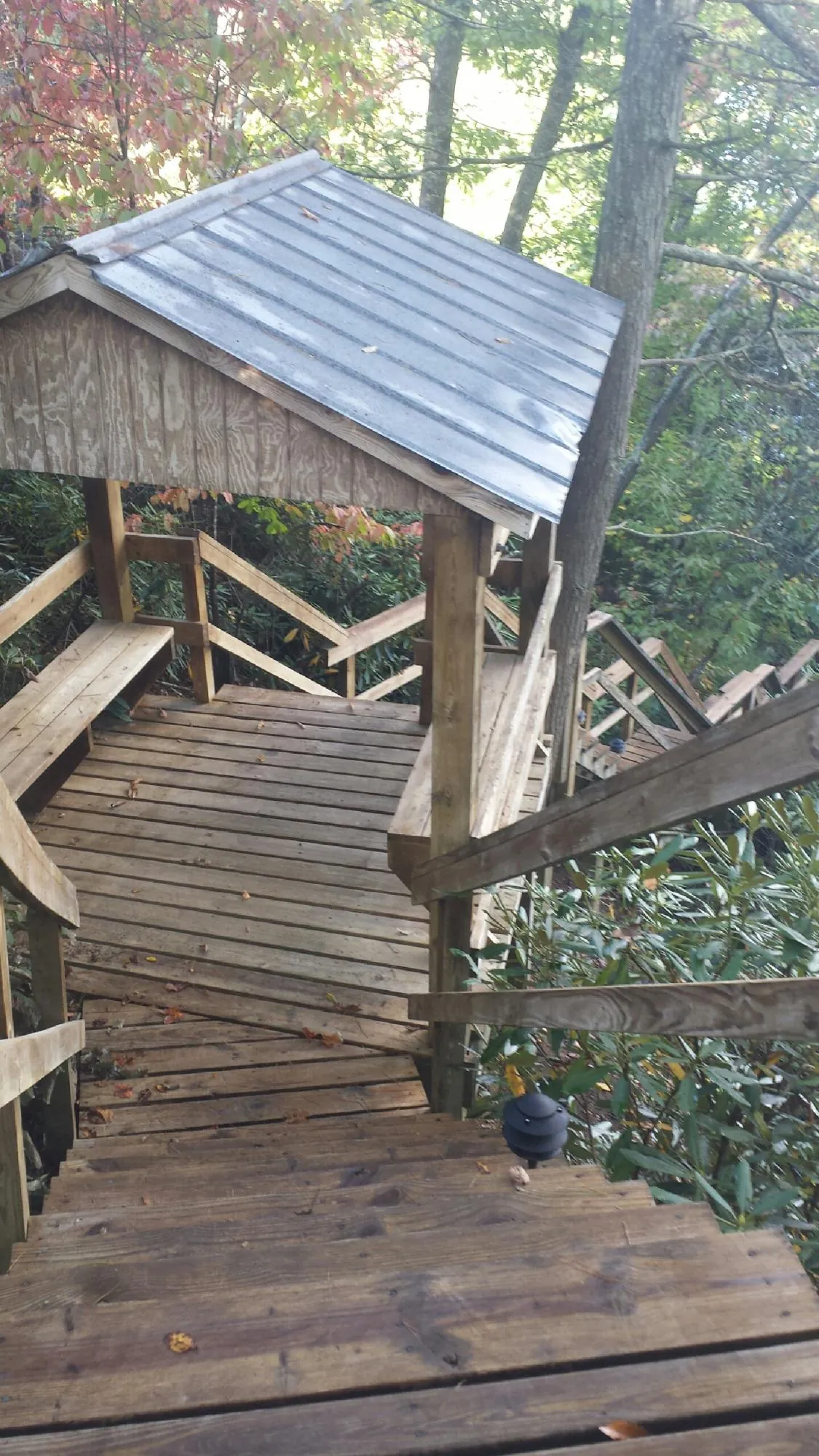 Metal roofed shelter over wooden steps on a wooded walkway — Skylight Repair & Installation work by our crew in Lisbon
