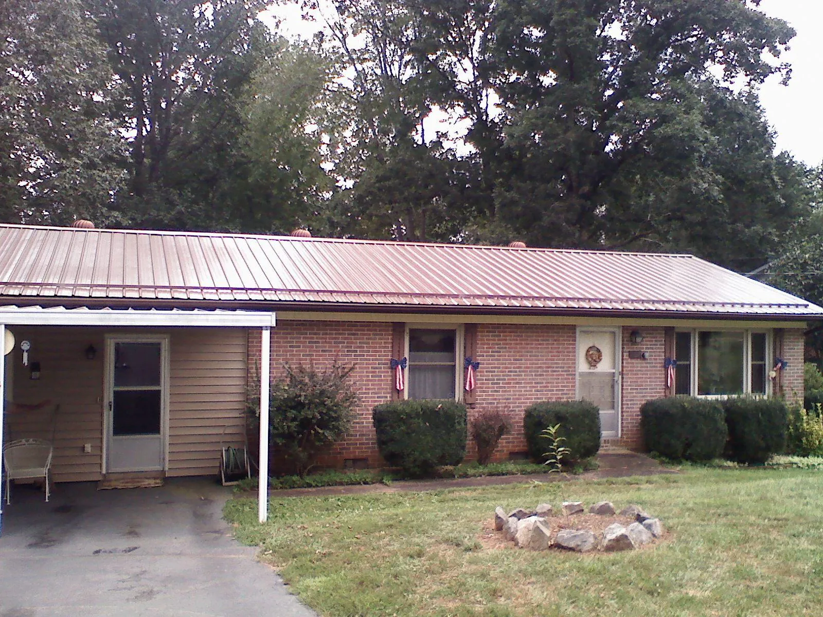 Bronze metal roof and carport on a brick ranch home — Roof Repair work by our crew in Lisbon